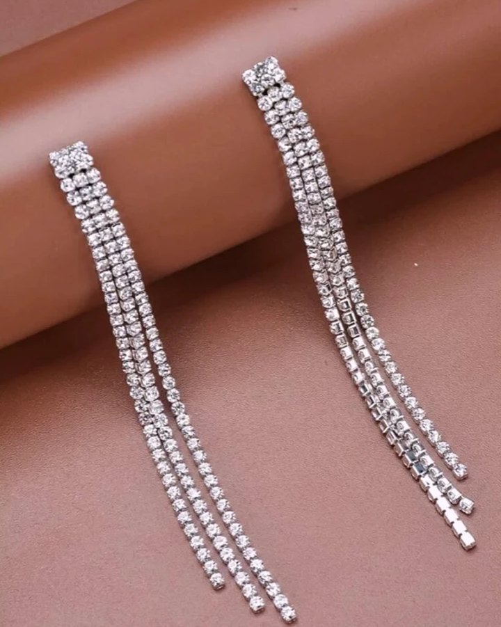 Long crystal tassel earrings on a blush background