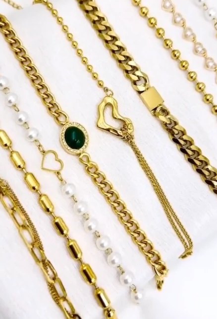 Gold chain and pearl bracelets laid out in a row